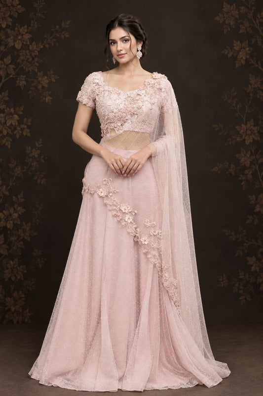 Soft pastel blush-pink lehenga saree in a delicate, flowy fabric with a subtle net.